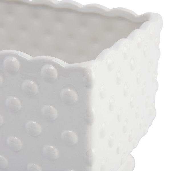 A white ceramic planter with a hobnail texture, scalloped edge, and polka dots.